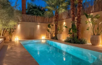 Illuminated apartment with private pool in Marrakech, framed by palm trees at dusk