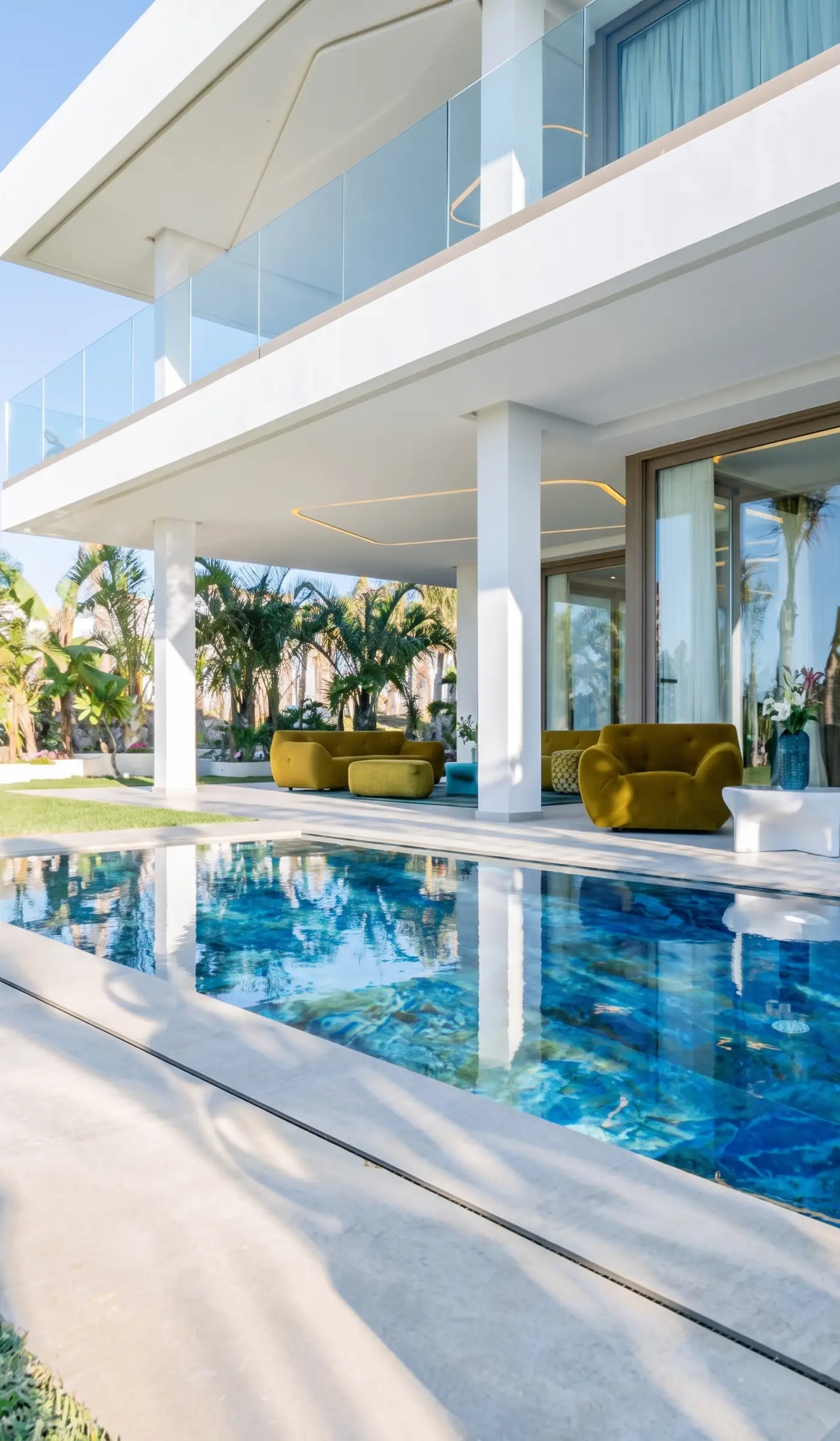 Contemporary villa pool with olive-green sofas and glass balustrade, a prime choice for Emirati investors buying property in Morocco
