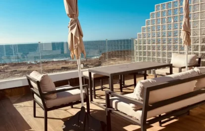 Terrace of an oceanfront villa for rent in Harhoura, with lounge seating, a dining table and open Atlantic views