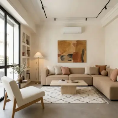 Lounge in an Asilah loft with an L-shaped beige sofa, travertine coffee table, Beni Ourain rug and built-in shelving